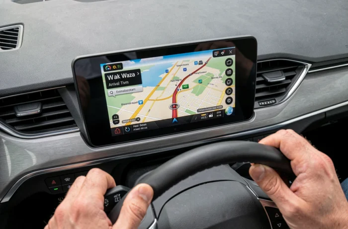 Écran GPS de voiture affichant l'interface de navigation Waze avec itinéraire et trafic
